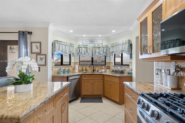 kitchen with light stone counters, stainless steel appliances, sink, light tile patterned flooring, and ornamental molding