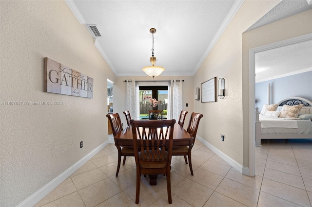 tiled dining room featuring lofted ceiling, a textured ceiling, and ornamental molding