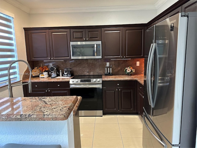 kitchen featuring appliances with stainless steel finishes, light tile patterned floors, dark brown cabinets, and decorative backsplash