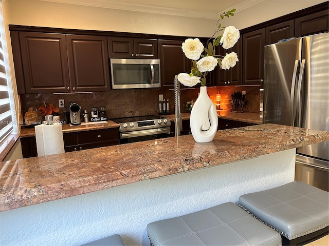 kitchen featuring crown molding, dark brown cabinetry, appliances with stainless steel finishes, and decorative backsplash