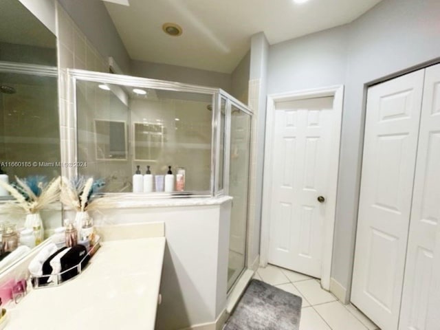 bathroom featuring a shower with door, vanity, and tile patterned flooring