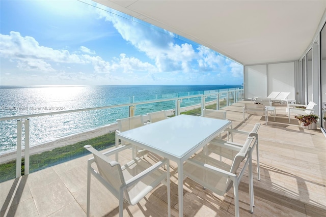 balcony featuring a water view and a view of the beach