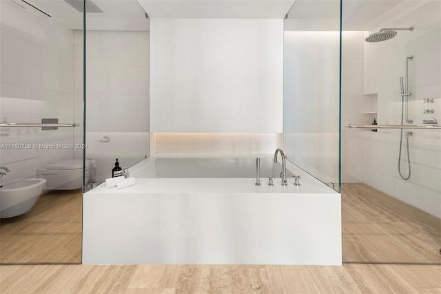 bathroom featuring toilet, separate shower and tub, tile walls, a bidet, and hardwood / wood-style flooring