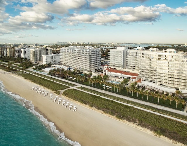 birds eye view of property with a water view and a beach view