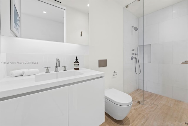 bathroom with vanity, toilet, and a tile shower