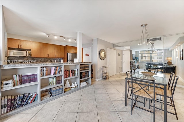 dining area with a notable chandelier and light tile patterned floors