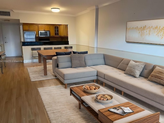 living room with hardwood / wood-style flooring and crown molding