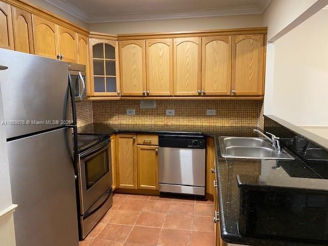 kitchen with tasteful backsplash, ornamental molding, stainless steel appliances, sink, and light tile patterned flooring