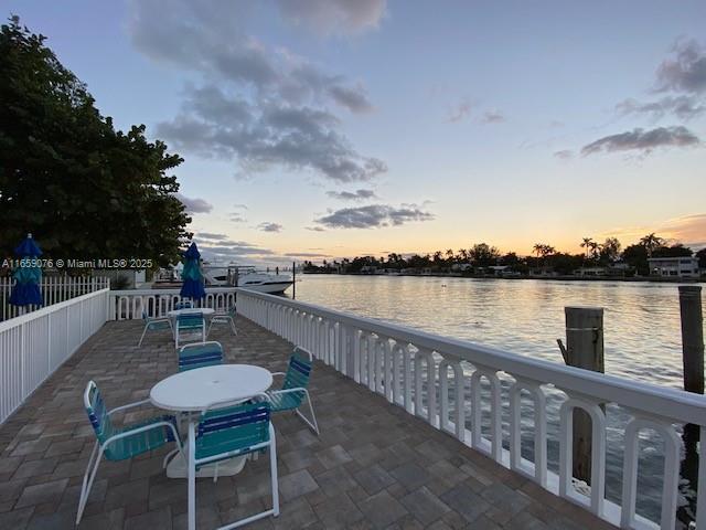 patio terrace at dusk featuring a water view