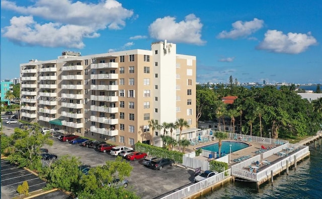 view of building exterior with a water view and a community pool