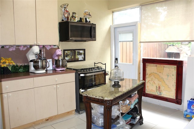 kitchen with cream cabinets, light tile patterned floors, and black range with electric cooktop