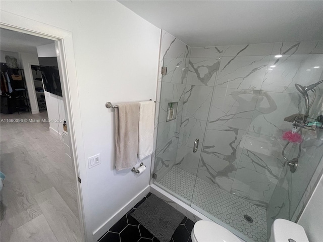 bathroom featuring hardwood / wood-style floors, toilet, and an enclosed shower