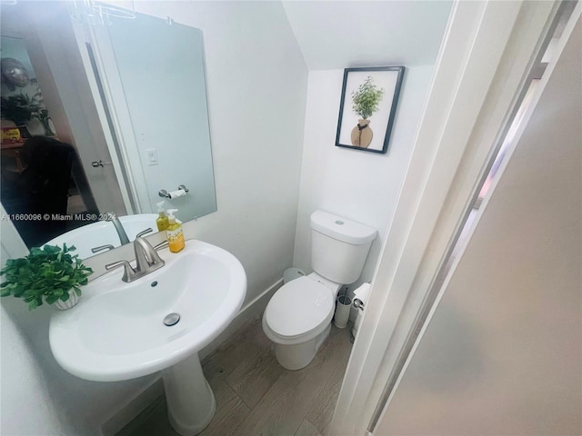 bathroom with toilet, sink, and hardwood / wood-style flooring