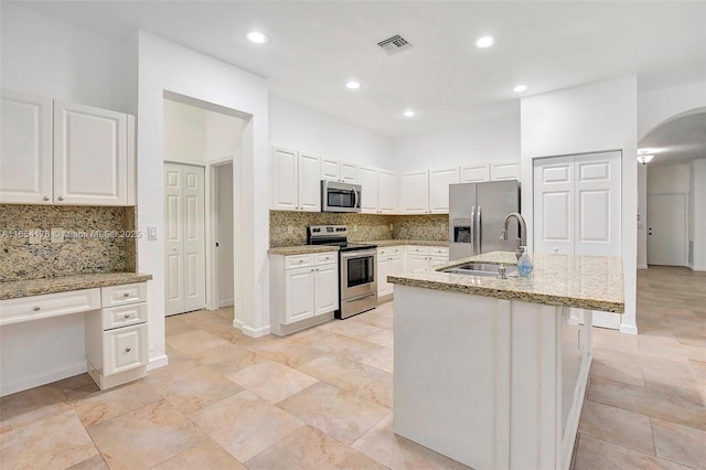 kitchen with tasteful backsplash, visible vents, a sink, and appliances with stainless steel finishes