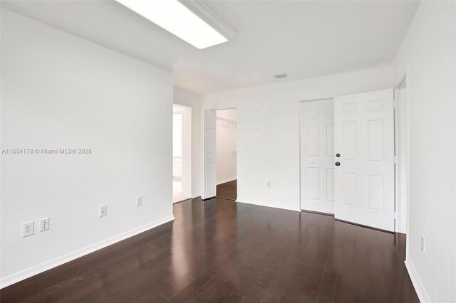 unfurnished bedroom with dark hardwood / wood-style flooring