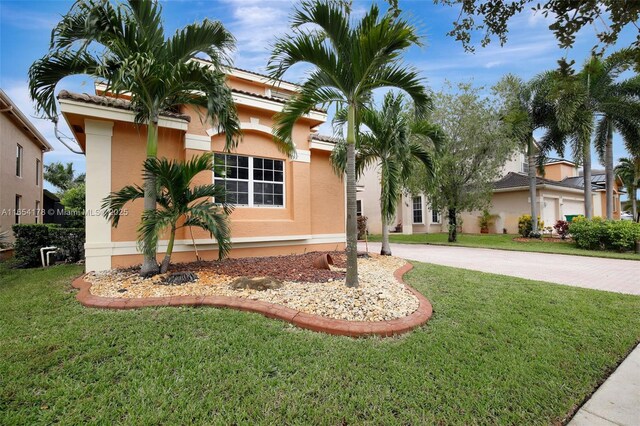 mediterranean / spanish-style house featuring a front yard and a garage