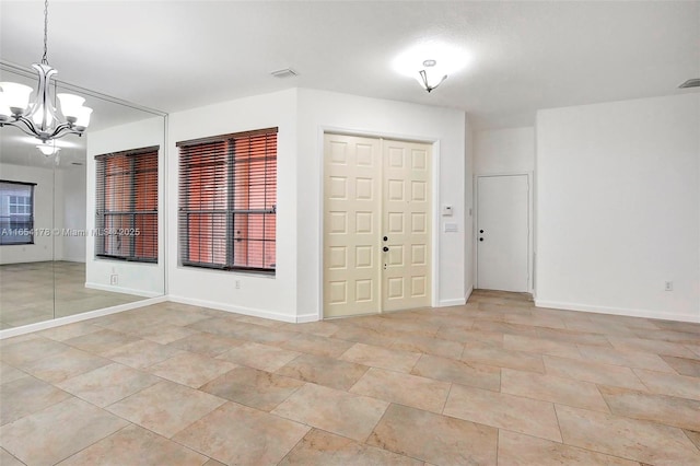 interior space with light tile patterned floors, a notable chandelier, baseboards, and visible vents
