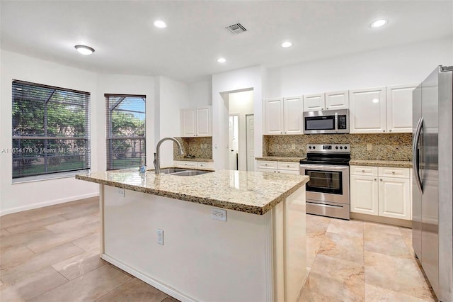 kitchen featuring visible vents, a sink, backsplash, and appliances with stainless steel finishes