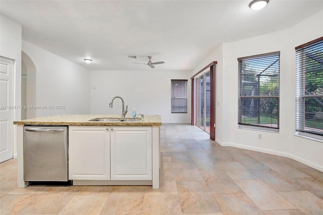 kitchen featuring white cabinetry, light stone countertops, ceiling fan, stainless steel dishwasher, and a sink