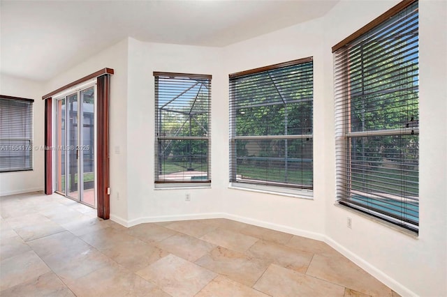 unfurnished room with light tile patterned floors and baseboards