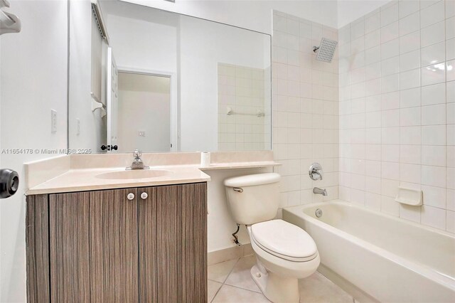 full bathroom featuring vanity, tile patterned floors, tiled shower / bath, and toilet