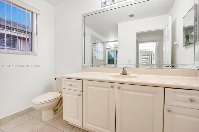 bathroom featuring vanity, tile patterned flooring, toilet, and a shower with shower door