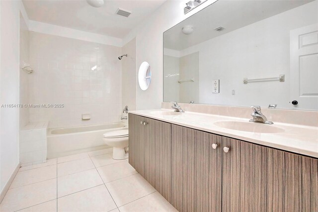 full bathroom with tiled shower / bath, vanity, toilet, and tile patterned floors