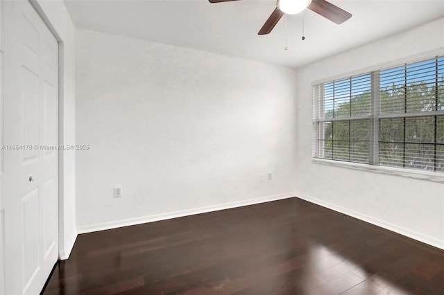 unfurnished room with dark wood-style flooring, baseboards, and a ceiling fan