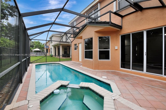 view of swimming pool featuring a lanai, an in ground hot tub, a patio area, and a lawn