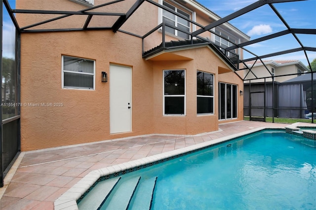 view of pool featuring a pool with connected hot tub, a patio, and a lanai