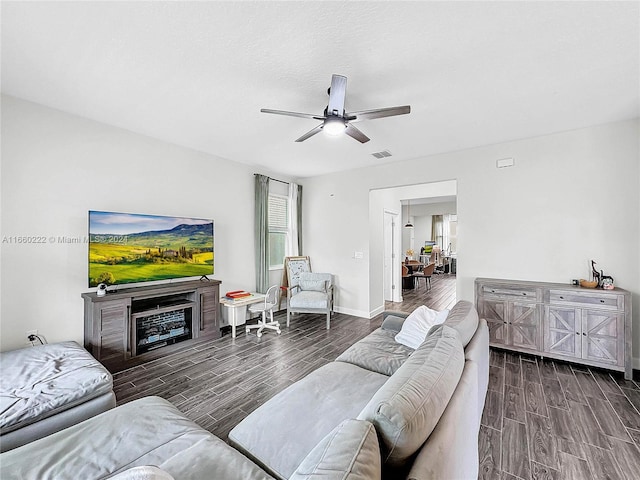 living room featuring ceiling fan and dark hardwood / wood-style floors