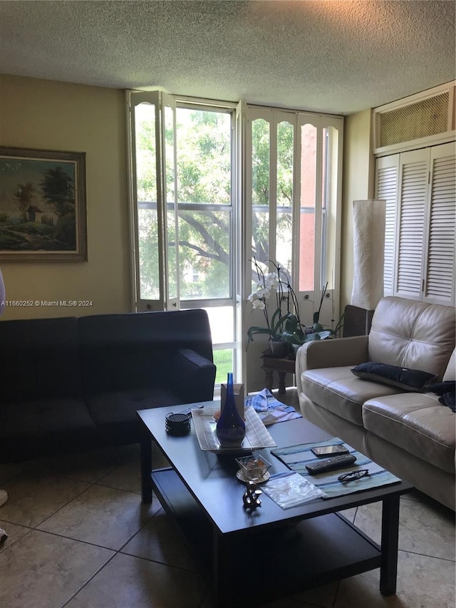 living room with a textured ceiling, plenty of natural light, and tile patterned flooring