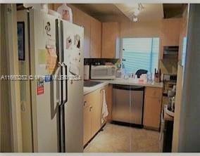 200 172nd St Unit 207, Sunny Isles Beach, FL 33160 - kitchen featuring stainless steel dishwasher, freestanding refrigerator, light countertops, and light tile patterned floors