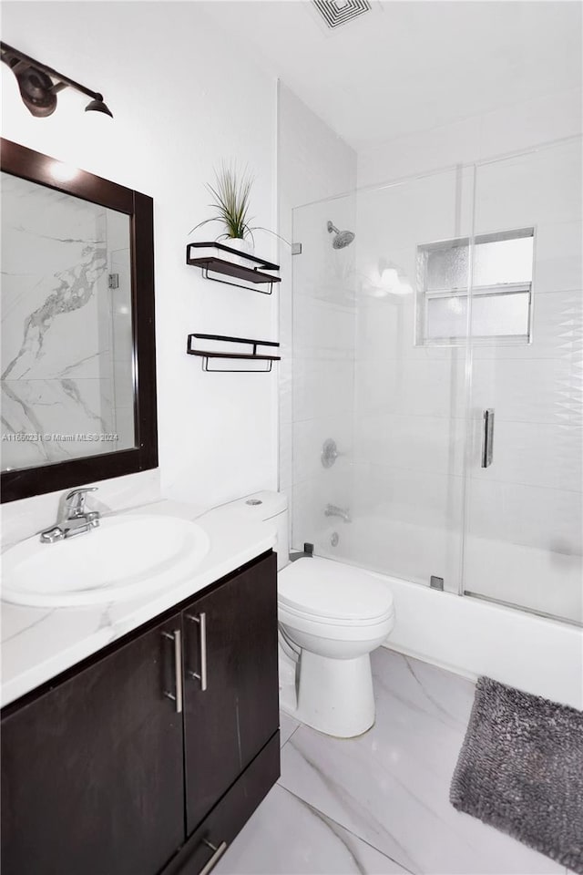 full bathroom with bath / shower combo with glass door, vanity, and toilet