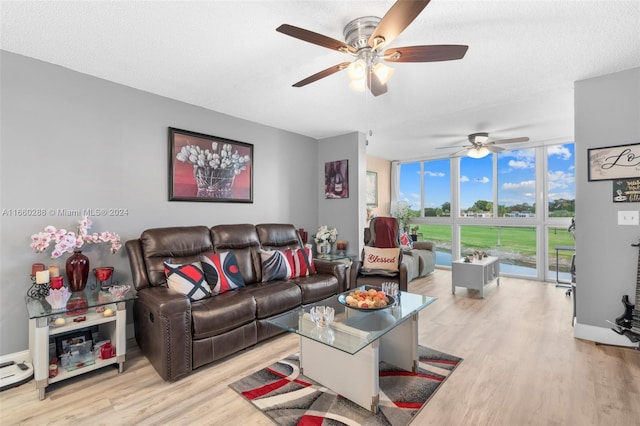 living room featuring ceiling fan, floor to ceiling windows, and light hardwood / wood-style flooring