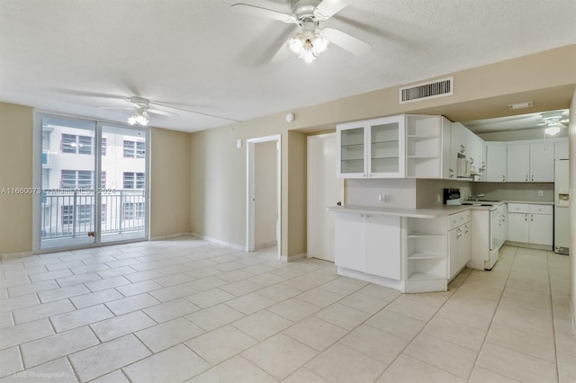 kitchen featuring a textured ceiling, ceiling fan, white appliances, and white cabinets