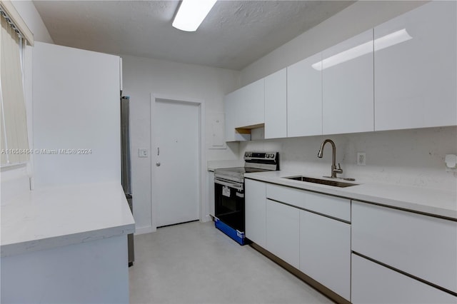 kitchen with range with electric stovetop, white cabinetry, sink, and a textured ceiling