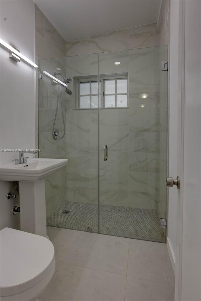 bathroom with toilet, an enclosed shower, and tile patterned floors