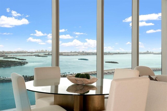 dining room featuring a water view and plenty of natural light