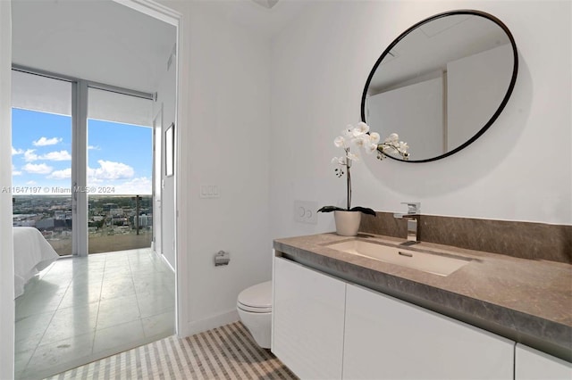 bathroom featuring vanity, tile patterned flooring, and toilet