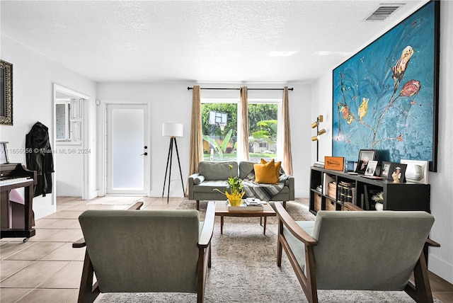 tiled living room featuring a textured ceiling