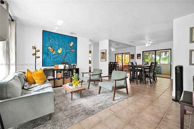 tiled living room with ceiling fan and a textured ceiling