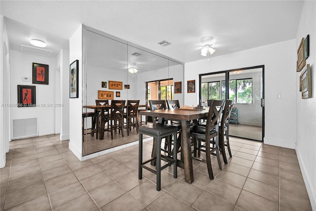 dining space with ceiling fan, light tile patterned floors, and a textured ceiling