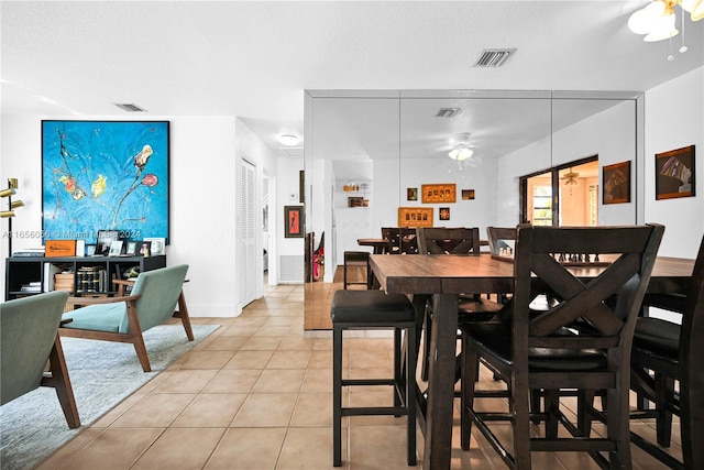 tiled dining room featuring ceiling fan and a textured ceiling