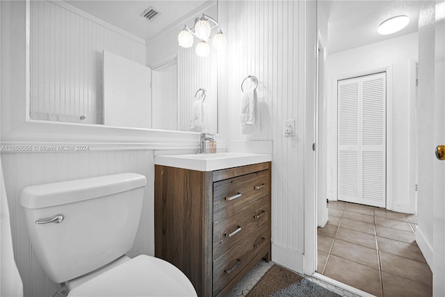 bathroom with tile patterned flooring, vanity, and toilet