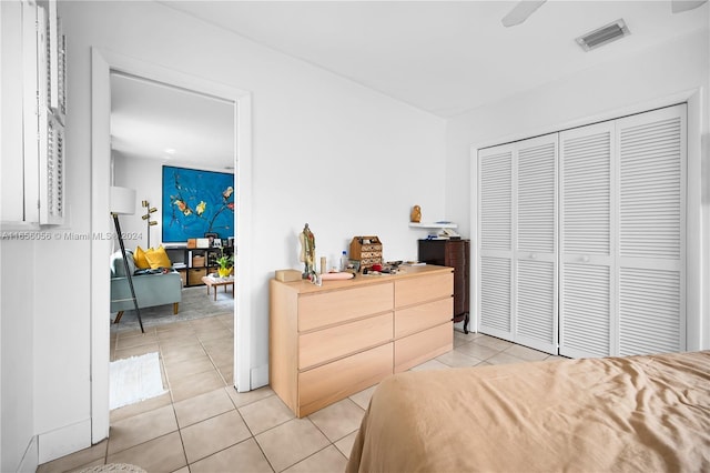 bedroom featuring light tile patterned floors, a closet, and ceiling fan