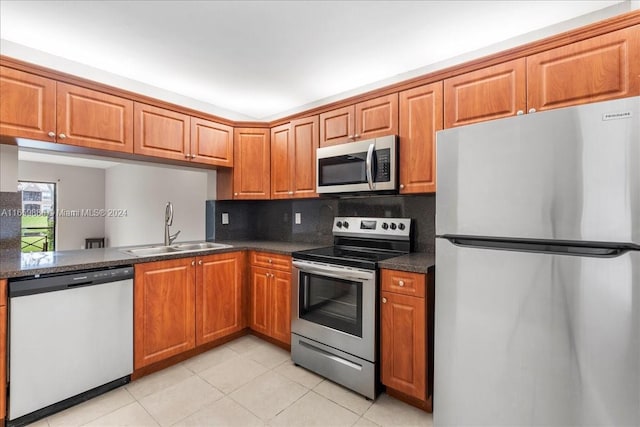 kitchen featuring stainless steel appliances, backsplash, light tile patterned floors, and sink