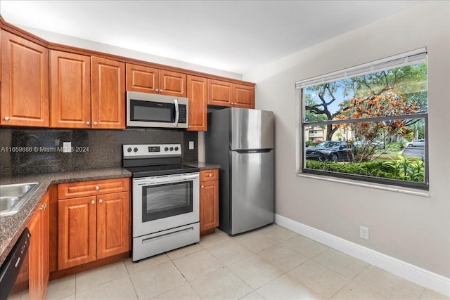 kitchen with light tile patterned floors, appliances with stainless steel finishes, and tasteful backsplash