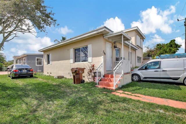 380 E 45th St, Hialeah, FL 33013 - view of front of house with a front yard, stucco siding, and entry steps