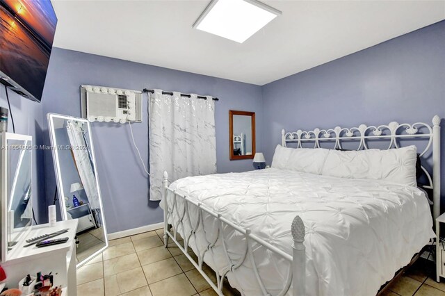 380 E 45th St, Hialeah, FL 33013 - tiled bedroom with baseboards and a wall mounted air conditioner